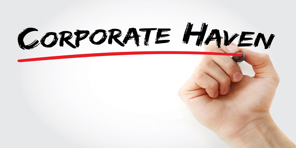 Hand underlining the words Corporate Haven in red, on a transparent board.